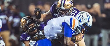 Washington football player tackle a Boise State player during the Las Vegas Bowl.